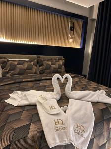 AMASRA DADAYLI HOTEL في أماسرا: مناشف بجعتين على سرير في غرفة الفندق