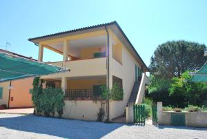 uma casa com uma escada em frente em Appartamento Amapola - Bilocale in zona mare con clima e posto auto em Marina di Campo