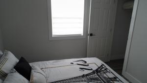 een bed in een kamer met een raam bij Charming Retreat on Rothesay Road in Saint John