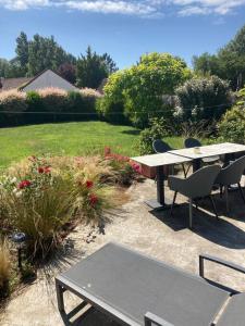 a patio with a table and chairs in a yard at Maison individuelle - Cucq in Merlimont