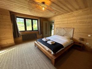 Poli Resort, calme et haut-de-gamme au sommet في كسونبورت-لونجمير: غرفة نوم بسرير في غرفة خشبية