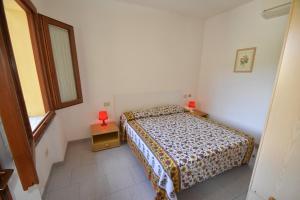 ein kleines Schlafzimmer mit einem Bett und einem Fenster in der Unterkunft Appartamento Amapola - Bilocale in zona mare con clima e posto auto in Marina di Campo