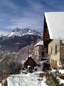 a building with a snow covered mountain in the background at Chalet de Pampo in Vaujany