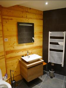 a bathroom with a sink and a wooden wall at Chalet de Pampo in Vaujany