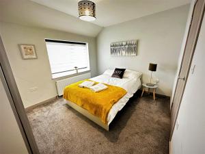 a bedroom with a bed with a yellow blanket and a window at Horizon House, Modern 2-Bedroom Flat 2, Parking, Netflix, Oxford in Oxford