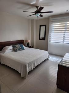 a bedroom with a bed and a ceiling fan at Cartagena la Boquilla amobaldo vista directa al mar a pocos pasos de playa in Santa Barbará