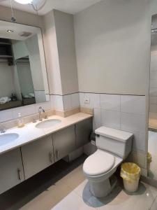 a bathroom with a toilet and two sinks and a mirror at Cartagena la Boquilla amobaldo vista directa al mar a pocos pasos de playa in Santa Barbará