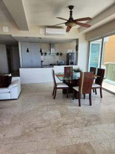 sala de estar con ventilador de techo, mesa y sillas en Apartamento 3 alcobas con vista frente al mar Morros 922, en Santa Barbará