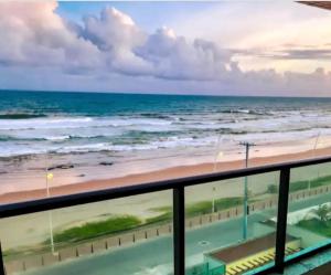 un balcone con vista sulla spiaggia di un condominio di Apartamento frente mar praia do flamengo a Salvador