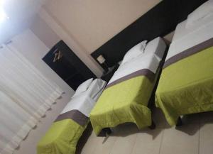 een slaapkamer met 2 bedden met groene en witte lakens bij Aquanovel in Los Órganos