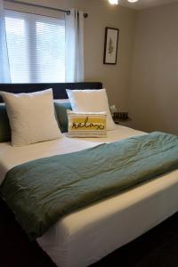1 cama con manta verde y almohadas en Cloud's Bnb - The Signature Suite, for cooks. en Elizabethtown