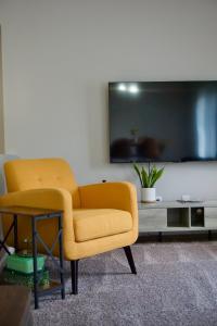 - Silla amarilla en la sala de estar con TV en Cloud's Bnb - The Signature Suite, for cooks. en Elizabethtown