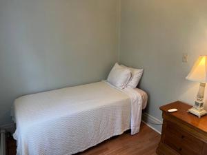 a small room with a bed and a lamp and a table at Amazing Location Train/NYC,Cafes in Montclair