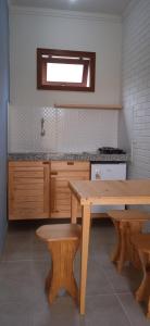 a kitchen with a wooden table and two benches at Studios da ilha praia do Francês in Praia do Frances