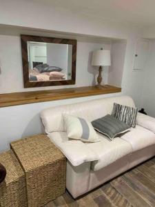 a living room with a white couch and a mirror at Studio by New York Harbor in Saint George