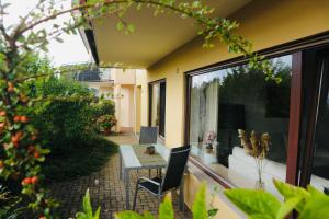 d'une terrasse avec une table et des chaises dans la cour. dans l'établissement Seeglanz-Apartment IStayUnixI Seenähe-Terrasse-Netflix, à Öhningen