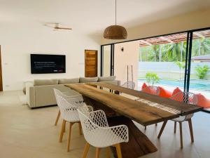 uma sala de estar com uma mesa de madeira e cadeiras em Private pool villa em Thongsala