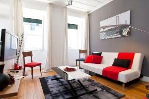 een woonkamer met een witte bank en rode kussens bij Lisbon Sant'Anna Apartments in Lissabon