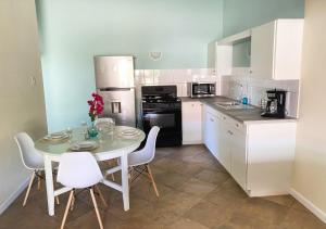 a kitchen with a table and chairs and a kitchen with white cabinets at Pura Vida Aruba Appartement Palma in Noord