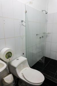 a bathroom with a toilet and a glass shower at HOTEL AMASH Chone in San Pablo
