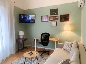 a living room with a couch and a desk and a tv at Casa in Centro. Nel cuore della città. in Chieti