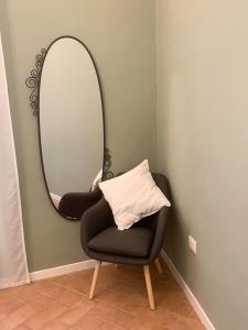 a mirror and a chair in a room at Casa in Centro. Nel cuore della città. in Chieti