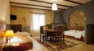 a bedroom with a bed and a table and chairs at Fanaras Hotel in Kalavrita