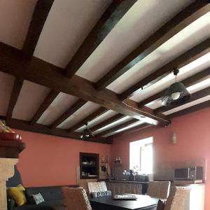 sala de estar con techos de madera, mesa y sillas en Casa Capricho, en Proaza