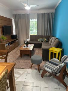 uma sala de estar com um sofá e uma mesa em Apartamendo na Enseada em Ubatuba