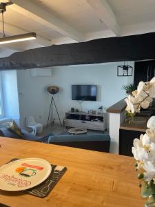 a living room with a table and a tv at Maison de campagne individuelle et patio in Poulan-Pouzols