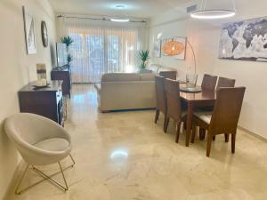 een woonkamer met een tafel en stoelen en een bank bij Apartment next to the El Campanario, Atalaya Golf in Estepona