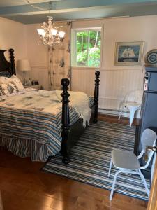1 dormitorio con 1 cama, 1 silla y 1 lámpara de araña en Chalets Plage St-Jean, en Saint-Jean