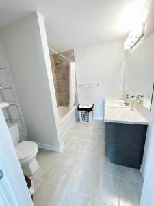 a bathroom with a toilet and a sink and a tub at 2 bedroom ensuite in Stittsville