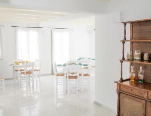 a white dining room with a table and chairs at Nastasia Village in Naxos Chora