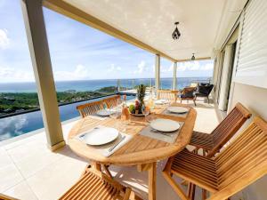 a dining room with a table and chairs on a balcony at Villa Grand Horizon with extraordinary 180 degree sea view in Saint Martin