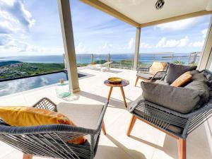 a living room with a view of the ocean at Villa Grand Horizon with extraordinary 180 degree sea view in Saint Martin