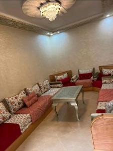 een woonkamer met banken en een tafel bij Super appartement in Aïn ej Jmel