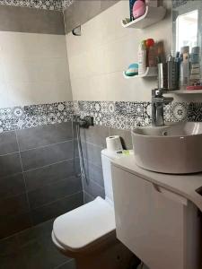 een badkamer met een wastafel en een toilet bij Super appartement in Aïn ej Jmel