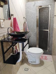 une salle de bain avec toilettes et une table avec lavabo dans l'établissement Jaspe, à Arraial do Cabo