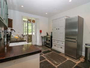 a large kitchen with a stainless steel refrigerator at Fell View in Millom