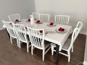 una mesa de comedor blanca con sillas blancas, una mesa blanca y un sillón en 2 bedroom ensuite, en Stittsville