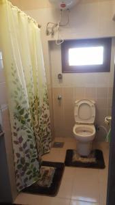a bathroom with a toilet and a shower curtain at City Square - Apartments With Stunning Sea View in Alexandria