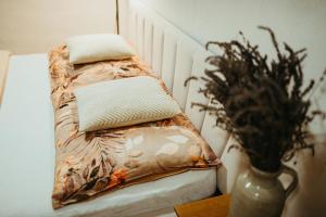 - un lit avec des oreillers et un vase sur une table dans l'établissement Apartmán v Jungovom dome - v centre Štiavnice, à Banská Štiavnica