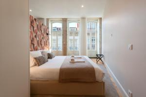 a bedroom with a large bed with a large window at Ando Living - Flores Townhouse in Porto