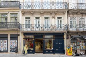 a store with a blue door in front of a building at Ando Living - Flores 200 House in Porto