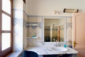 een badkamer met een wastafel en een spiegel bij BB Sa Mangaliana in Villagrande Strisaili