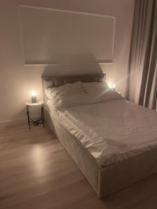 a bed in a bedroom with two candles on a side table at AirPort Apartment in Warsaw