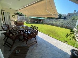 a patio with a table and chairs and a lawn at ANCA apartment in Paleo Tsifliki