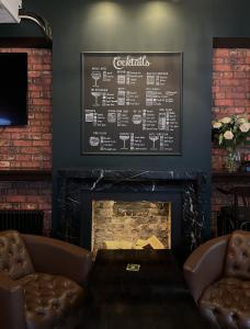 een open haard in een bar met een schoolbord aan de muur bij The Wellington Hotel Birmingham - Breakfast Included City Centre Near O2 Academy in Birmingham