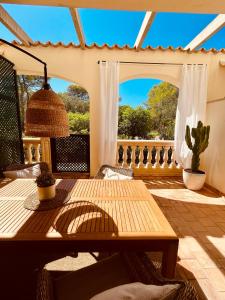 un patio con una mesa de madera y una ventana en Can Somni - Appartement bohème, zen et chic avec piscine en Cala Figuera